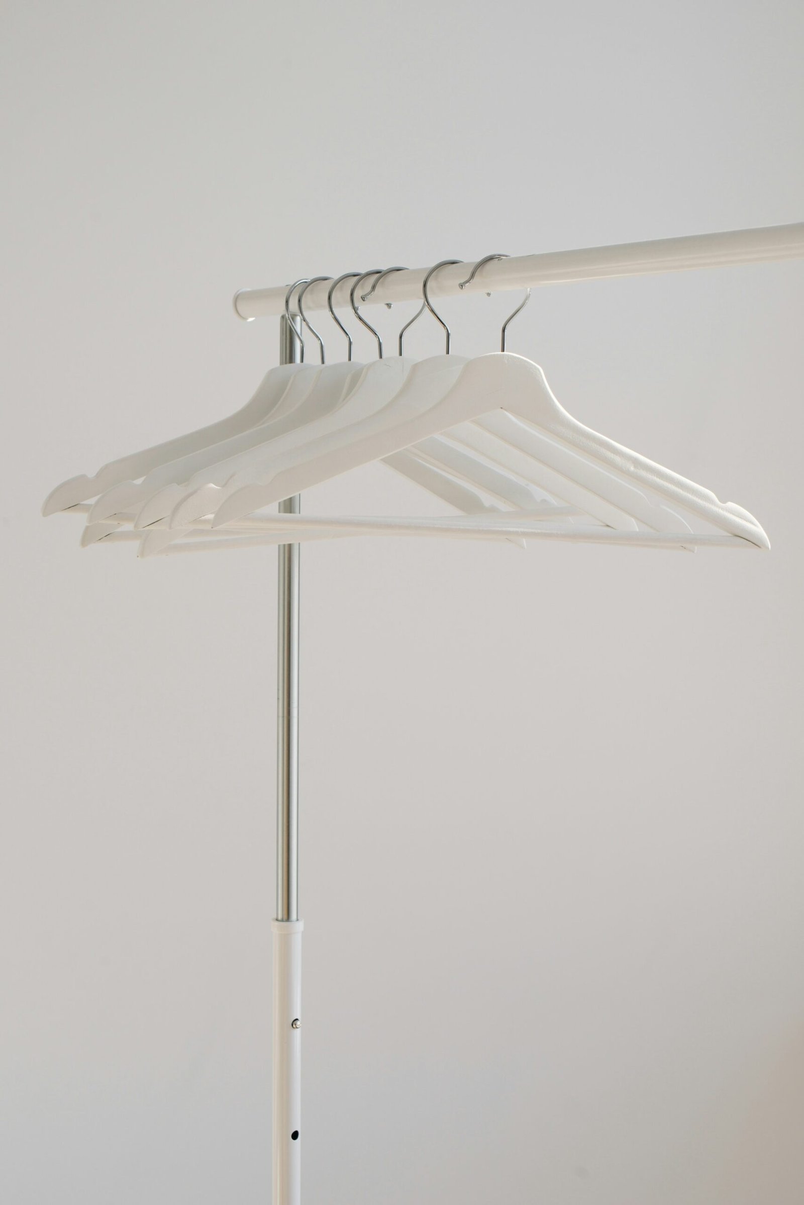 white clothes hangers hanging on rack